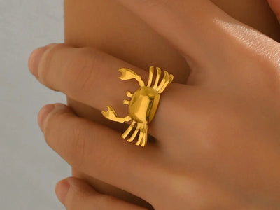 Immagine contenente l'anello placcato oro a forma di granchio indossato su una mano elegante