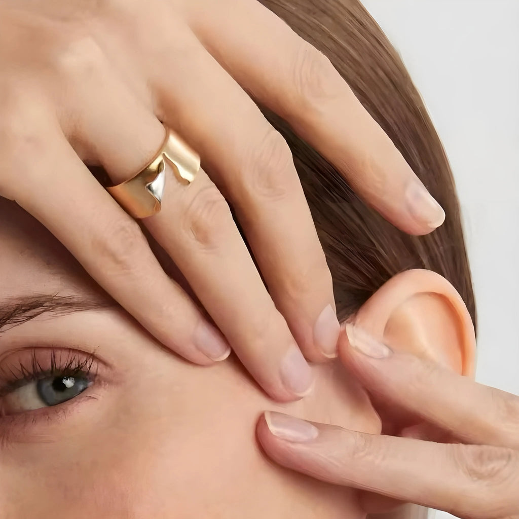 Donna con anello Charlotte BEHI MILANO in acciaio dorato 18k PVD, mani sul viso, occhio visibile.