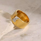 Anello BEHI Charlotte in acciaio placcato oro 18k PVD, design a onda con inserto argento lucido, raffinato splendore.
