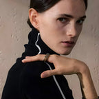 Das Model trägt einen zweifarbigen Ring von Onda BEHI MILANO aus 18 Karat Gold und Stahl. Raffiniertes Schmuckstück am Finger.