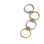 BEHI MILANO zweifarbiger Onda-Ring mit 2 glatten Stahlringen und 2 strukturierten 18-Karat-Goldringen auf weißem Hintergrund. Raffiniert.