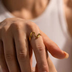 Anello BEHI JOJO regolabile dal design ondulato, placcato oro 18k, indossato su una mano femminile. Gioiello versatile.