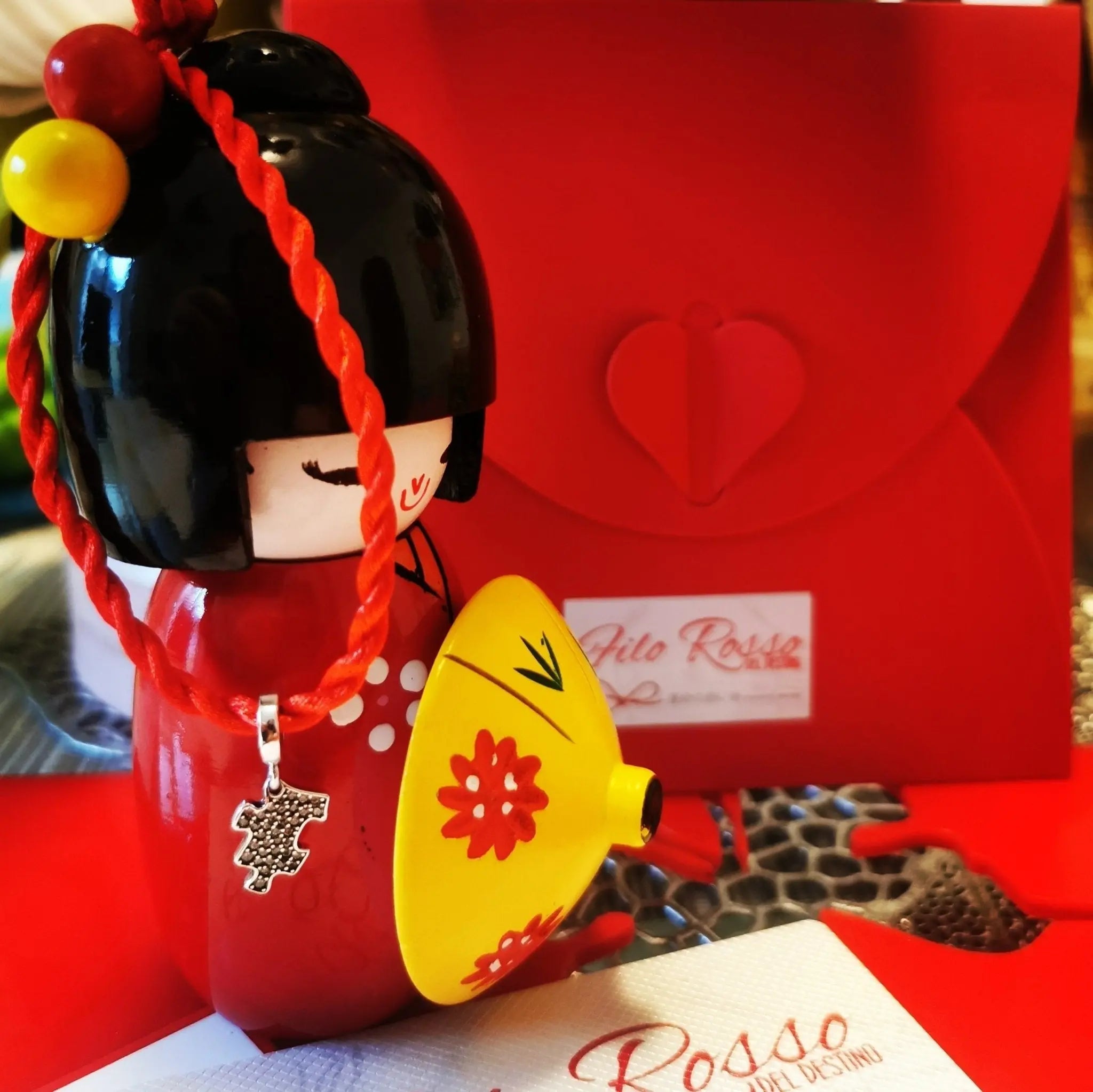 Charm Puzzle argento S925 su bambola Kokeshi rossa con busta regalo Filo Rosso, simbolo di unione e affinità.
