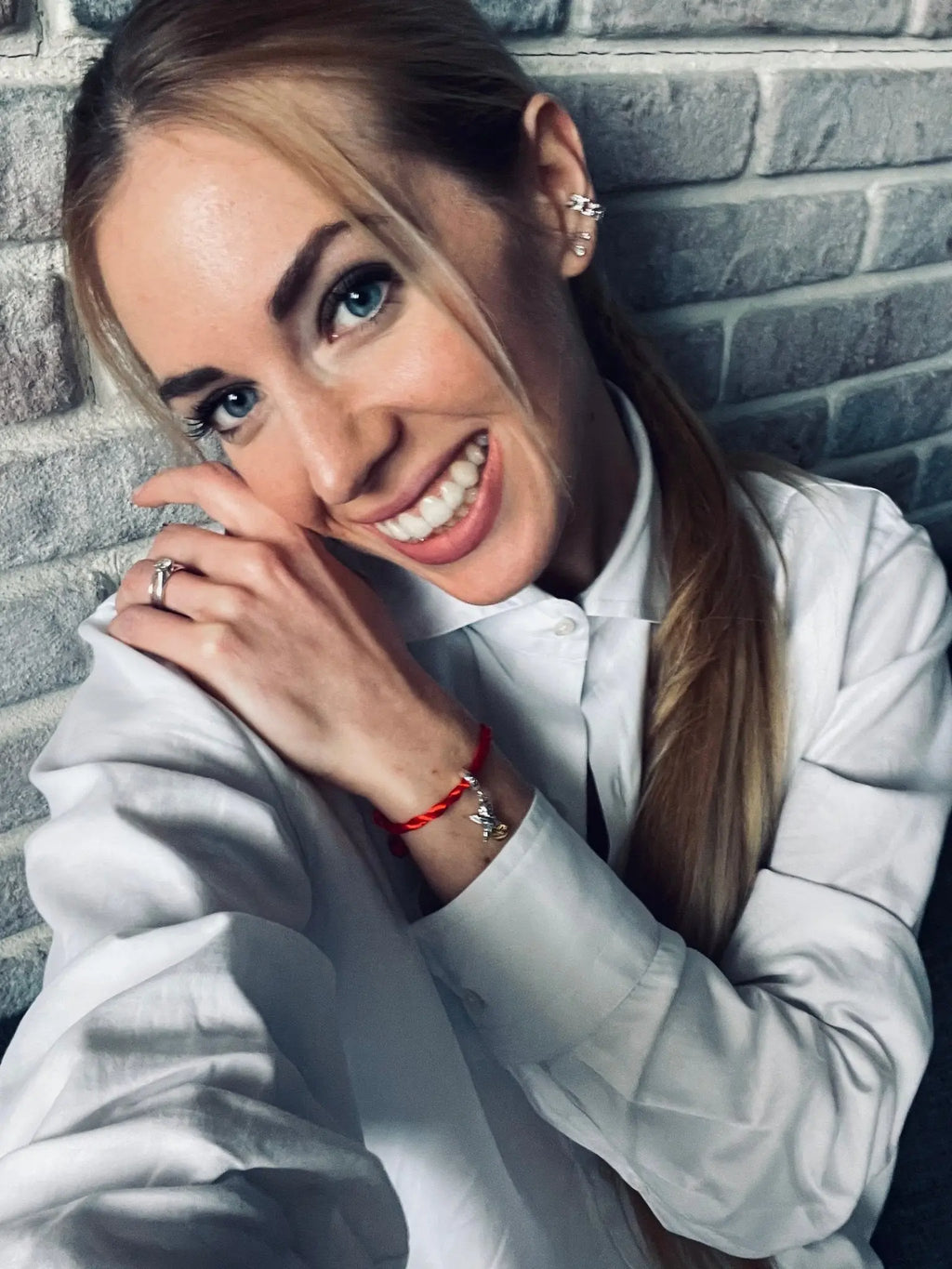 Donna sorridente con Filo Rosso e Charm Cupido in argento S925, simbolo d'amore e connessione.