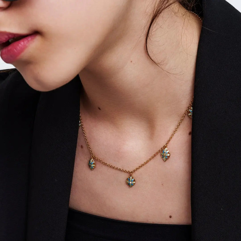 Donna con collana 'Leaf Me' in argento 925 placcato oro 18k, ciondoli a foglia smaltati azzurri/blu, dettaglio