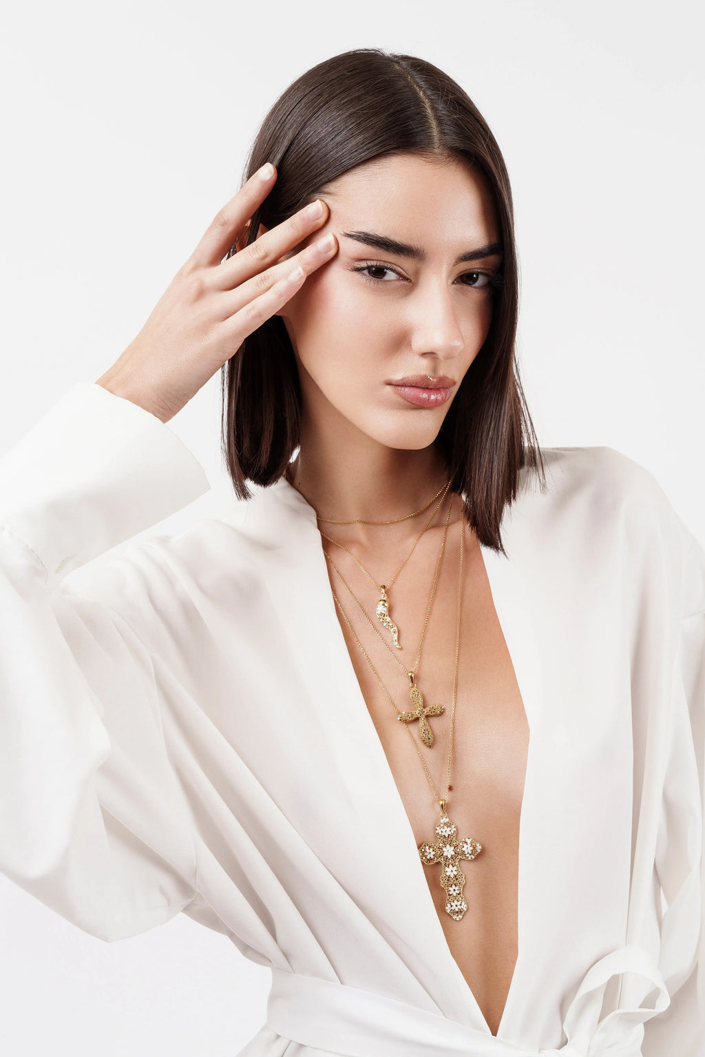 Modella indossa collana Cornetto Argento 925 placcato oro e collane croce, look stratificato. Gioielli MINA MINA.