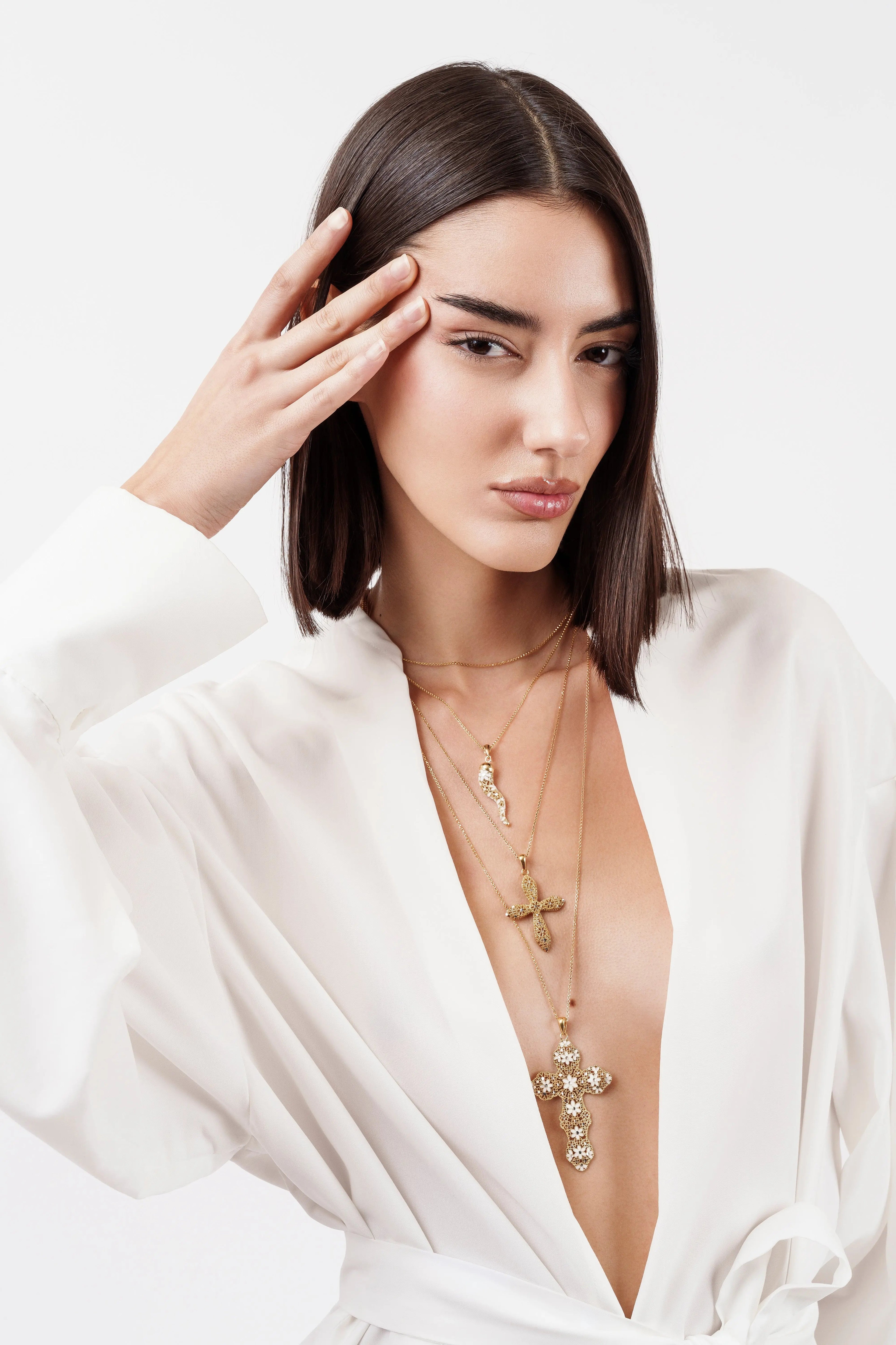 Modella indossa collana Cornetto Argento 925 placcato oro e collane croce, look stratificato. Gioielli MINA MINA.