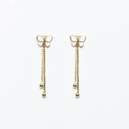 Orecchini Mini Farfalla MINA MINA pendenti in argento 925 placcato oro 18k con catene e sfere su sfondo bianco.